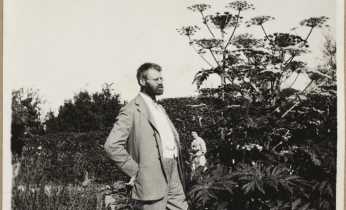 Axel Olrik i sin have. I bagggrunden hans hustru, Sofie”. U.å., ukendt fotograf.